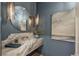 Stylish powder room with marble countertop, designer lighting, and sophisticated art, creating a luxurious feel at 1084 Wrights Mill Rd, Canton, GA 30115