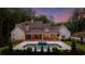Beautiful home boasts a large in-ground pool with spa, fire features, a covered patio and manicured lawn at 1084 Wrights Mill Rd, Canton, GA 30115