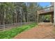 A spacious, fenced backyard with lush green grass leading to a deck with a hot tub, perfect for relaxation at 308 Evening Rain Crst, Canton, GA 30114