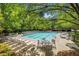 A community pool surrounded by lounge chairs and mature trees at 308 Evening Rain Crst, Canton, GA 30114