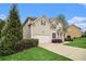Beautiful home with a well-maintained lawn, lush shrubbery and a view of the side entrance at 308 Evening Rain Crst, Canton, GA 30114