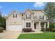 Charming two-story home featuring manicured lawn, a two-car garage, and classic architectural details at 308 Evening Rain Crst, Canton, GA 30114