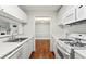 Clean kitchen with stainless steel sink, white appliances, and wood floors, offering a view into another room at 516 Summit North Ne Dr, Atlanta, GA 30324