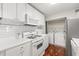 Bright kitchen features white cabinets, countertops, and appliances, with a laundry area in the background at 516 Summit North Ne Dr, Atlanta, GA 30324