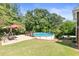 Backyard area with an above-ground pool, lounge swing, patio, and lush green trees at 5360 Franklin Goldmine Rd, Cumming, GA 30028