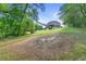 Large backyard with mature trees, grassy area, and play set offers ample space for outdoor fun at 5360 Franklin Goldmine Rd, Cumming, GA 30028