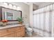 Well-lit bathroom featuring a vanity with floral decor and a shower with a patterned curtain at 5360 Franklin Goldmine Rd, Cumming, GA 30028