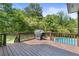 Wooden deck with built-in grill overlooking the backyard with above ground pool and patio at 5360 Franklin Goldmine Rd, Cumming, GA 30028