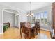Formal dining room with hardwood floors, modern chandelier, and a large window for natural light at 5360 Franklin Goldmine Rd, Cumming, GA 30028