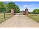 Long driveway leading to a brick home, enhanced by stately brick and iron entrance gates at 5360 Franklin Goldmine Rd, Cumming, GA 30028