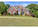 Beautiful brick home featuring manicured landscaping and a circular driveway at 5360 Franklin Goldmine Rd, Cumming, GA 30028