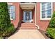 Covered front porch with brick steps, decorative door with glass and sidelights at 5360 Franklin Goldmine Rd, Cumming, GA 30028