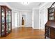Open hallway with hardwood floors and classic display cabinets at the end of the hall at 5360 Franklin Goldmine Rd, Cumming, GA 30028