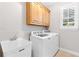 Functional laundry room equipped with a sink, washer, dryer, and built-in cabinets at 5360 Franklin Goldmine Rd, Cumming, GA 30028