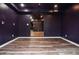 Finished basement showcasing laminate flooring, painted purple walls, and an arched entryway at 970 Winding Creek Trl, Sandy Springs, GA 30328