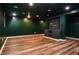 Spacious finished basement featuring a built-in entertainment center, wood-look flooring, and green walls at 970 Winding Creek Trl, Sandy Springs, GA 30328