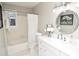 Bright bathroom featuring a shower-tub combo, white vanity, and decorative mirror at 970 Winding Creek Trl, Sandy Springs, GA 30328