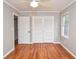 Empty bedroom featuring hardwood floors, neutral walls, and a large closet with sliding doors at 970 Winding Creek Trl, Sandy Springs, GA 30328