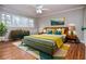 Staged bedroom with hardwood floors, ceiling fan, dresser, and a bed at 970 Winding Creek Trl, Sandy Springs, GA 30328