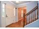 Welcoming entryway with hardwood floors, classic white trim, and staircase with wood railing at 970 Winding Creek Trl, Sandy Springs, GA 30328