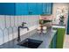 Close up of modern kitchen with stone countertops, sink, and geometric tile backsplash at 970 Winding Creek Trl, Sandy Springs, GA 30328