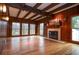 Inviting living room with wood paneling, beamed ceiling, fireplace, and large windows at 970 Winding Creek Trl, Sandy Springs, GA 30328