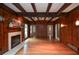 Living room with wood paneling, beamed ceiling, fireplace, and access to multiple rooms at 970 Winding Creek Trl, Sandy Springs, GA 30328