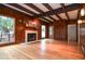 Living room with wood paneling, beamed ceiling, fireplace, and access to other rooms at 970 Winding Creek Trl, Sandy Springs, GA 30328