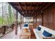 Wide, covered wooden porch with wood and stone supports showcases long views of the deck and landscaping at 970 Winding Creek Trl, Sandy Springs, GA 30328