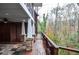 Spacious wooden porch with stone column bases offers a scenic view of the surrounding trees and lush greenery at 970 Winding Creek Trl, Sandy Springs, GA 30328