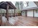 Spacious wooden deck with pergola, built-in seating and views to the home's exterior and porch at 970 Winding Creek Trl, Sandy Springs, GA 30328