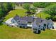 Aerial view of the luxury home, with a circular driveway, expansive green lawn, and wooded surroundings at 2305 Braselton Hwy, Buford, GA 30519