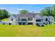 The backyard features a large green lawn, patio and views of the luxury home at 2305 Braselton Hwy, Buford, GA 30519