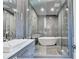 A modern bathroom with gray tile, walk in shower, and luxurious standalone tub at 2305 Braselton Hwy, Buford, GA 30519