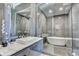 A sleek bathroom with modern fixtures, gray tile, glass shower, and a standalone tub at 2305 Braselton Hwy, Buford, GA 30519
