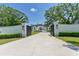 Elegant white brick home with a gated entrance and long driveway, surrounded by lush landscaping and mature trees at 2305 Braselton Hwy, Buford, GA 30519