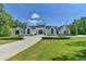 Elegant white brick home with manicured lawn and long driveway leading to the grand entrance at 2305 Braselton Hwy, Buford, GA 30519