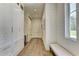 Bright hallway with white shiplap walls, hardwood floors, storage cabinets, and a window seat at 2305 Braselton Hwy, Buford, GA 30519