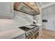 Gourmet kitchen with stainless steel stove, hood, and a luxurious marble backsplash at 2305 Braselton Hwy, Buford, GA 30519