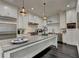 Bright kitchen with island, stainless appliances, and decorative lighting at 2305 Braselton Hwy, Buford, GA 30519