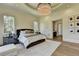 Spacious main bedroom featuring a modern chandelier, a large bed, and an ensuite bathroom entrance at 2305 Braselton Hwy, Buford, GA 30519