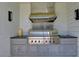 Outdoor kitchen featuring a stainless steel Wolf grill and hood set in a white brick surround at 2305 Braselton Hwy, Buford, GA 30519