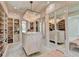 A luxurious walk-in closet with mirrored wardrobes, a central island, and a glamorous chandelier at 2305 Braselton Hwy, Buford, GA 30519