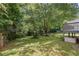 Grassy backyard with a mature tree, a wooden fence and a deck at 3310 Chartwell Blvd, Suwanee, GA 30024