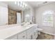 A luxurious bathroom featuring a vanity with a white countertop and decorative light fixture at 3310 Chartwell Blvd, Suwanee, GA 30024