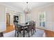 Charming dining room featuring hardwood floors, a modern chandelier, and natural light from shuttered windows at 3310 Chartwell Blvd, Suwanee, GA 30024