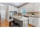 Updated kitchen boasts white cabinets, granite counters, stainless appliances, and island with bar seating at 3310 Chartwell Blvd, Suwanee, GA 30024