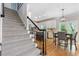 Carpeted staircase with iron railing leads to an open-concept kitchen and dining area at 3310 Chartwell Blvd, Suwanee, GA 30024