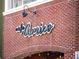 Close-up of the 'Cafe Amico' sign on a brick building with decorative lighting at 3930 Charleston Market St # 221, Suwanee, GA 30024
