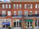 Charming three-story brick building featuring retail spaces and residential units with balconies above shops at 3930 Charleston Market St # 221, Suwanee, GA 30024